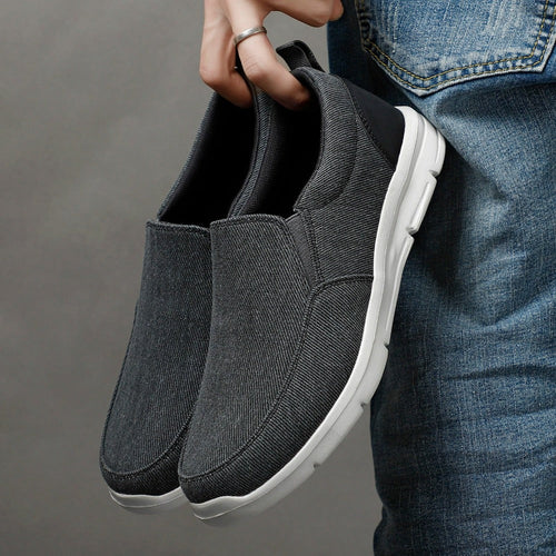 ELITE CASA Men’s Breathable Walking Sneakers in grey being held by a person, showcasing their stylish design.