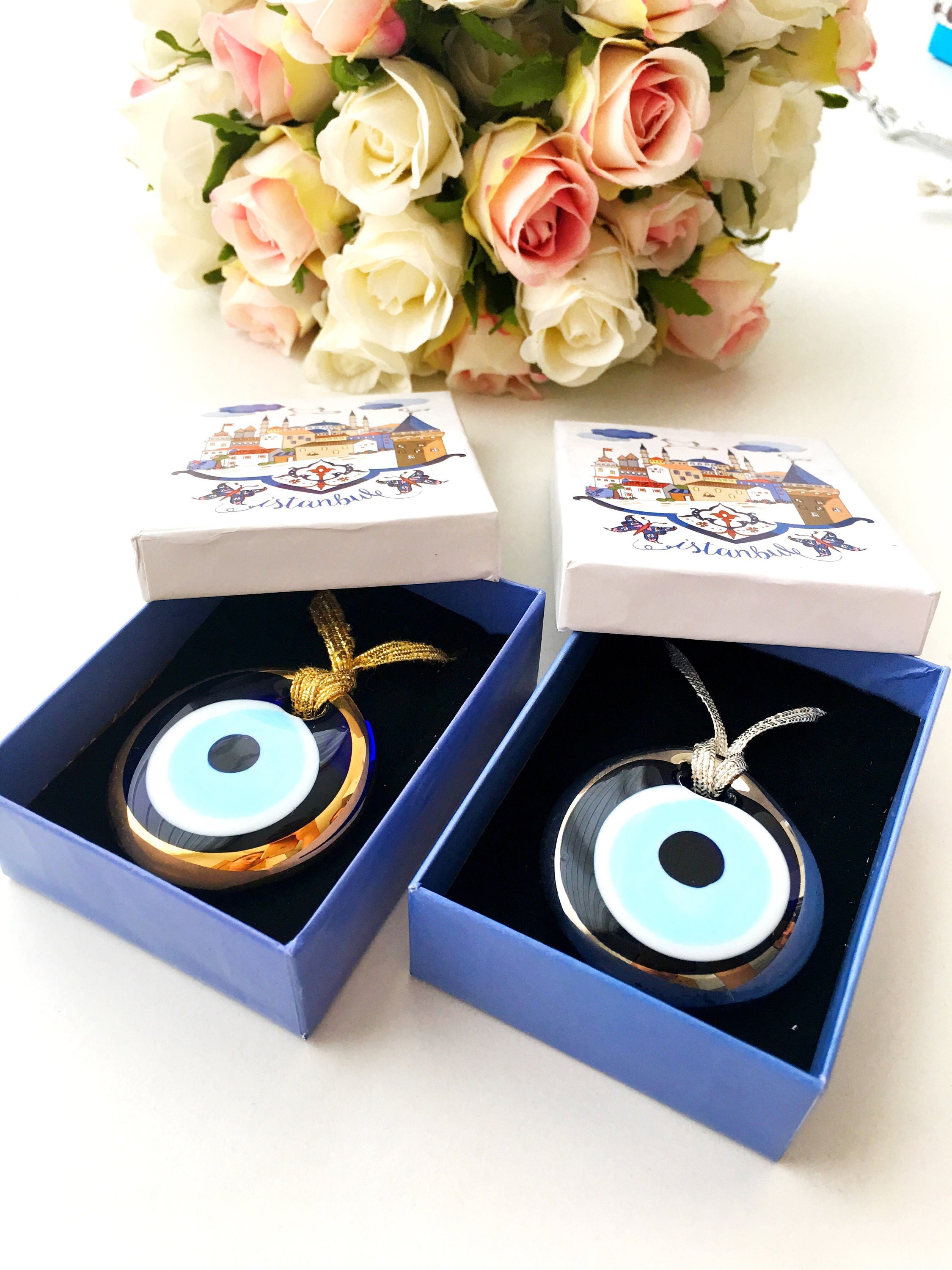 ELITE CASA Christmas gift ideas featuring blue evil eye charm in decorative boxes.
