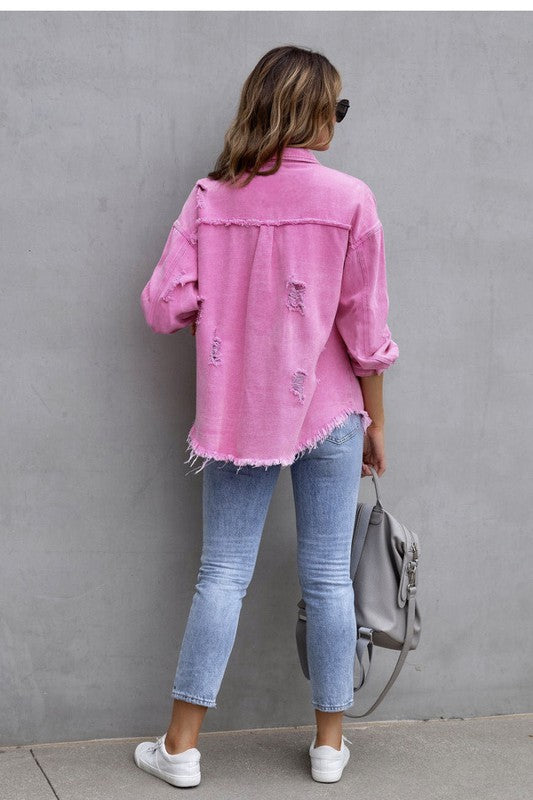 Woman wearing an ELITE CASA Tattered Jacket in pink, paired with light jeans and a grey bag against a neutral backdrop.