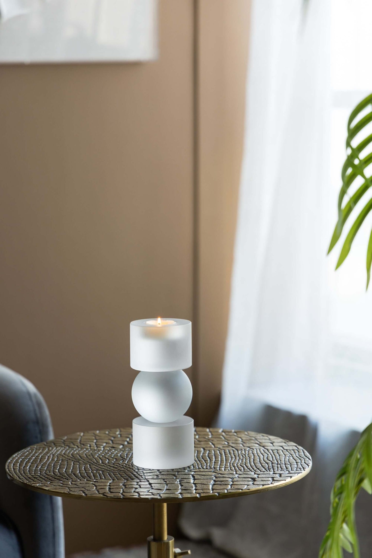 ELITE CASA polished candle holder displayed on a gold table, enhancing modern home decor with soft lighting.