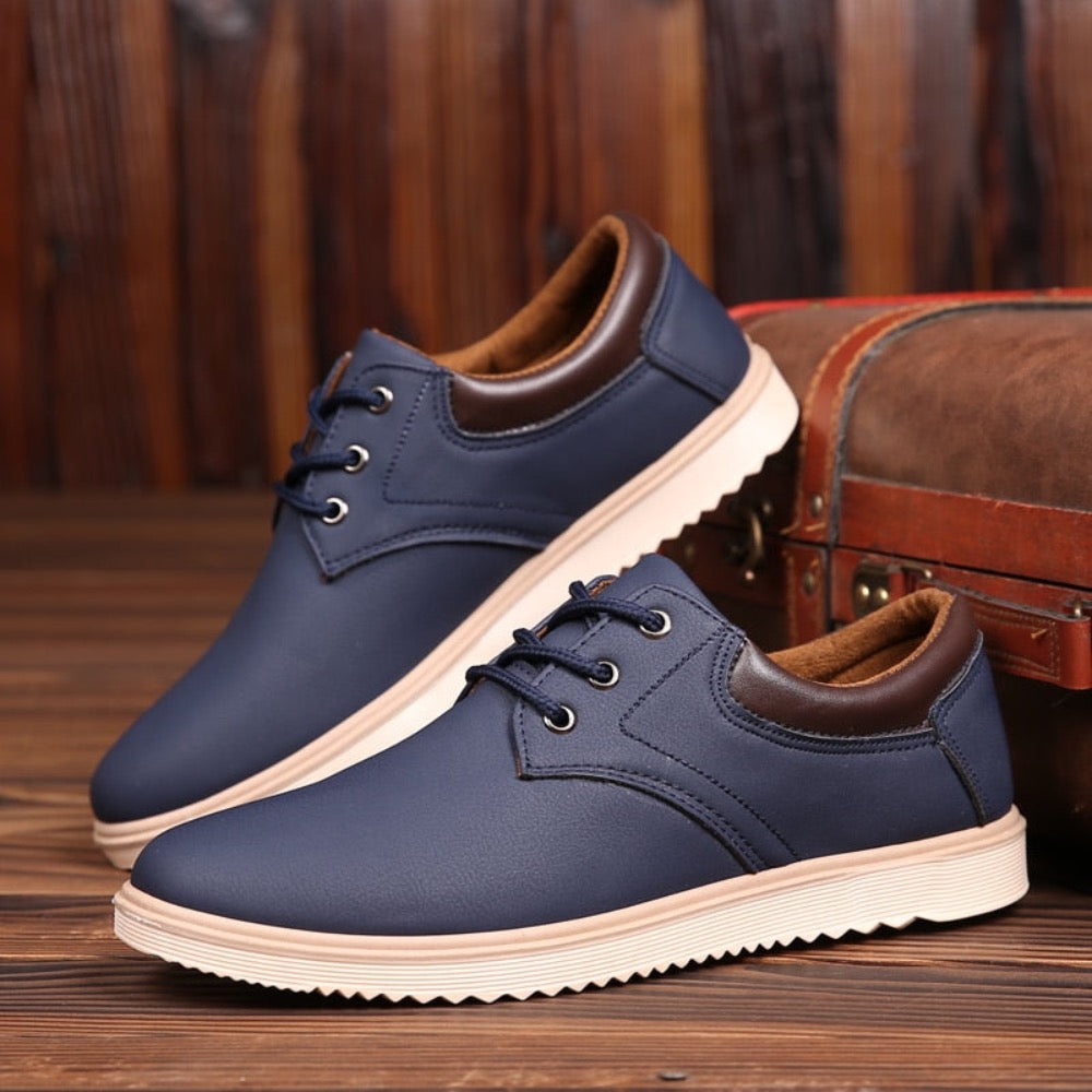 ELITE CASA Men’s Casual Flat Oxford Sneakers in navy blue with brown accents on a wooden background.